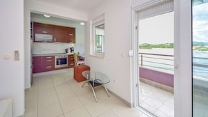 Eine moderne Küche mit Essbereich, ein Balkon mit Blick und eine Glastür.