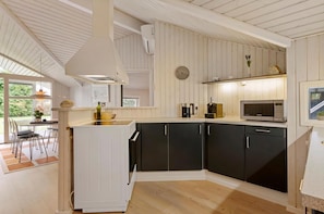 Eine moderne Küche mit schwarzen Schränken, einem weißen Kühlschrank und einer Mikrowelle.