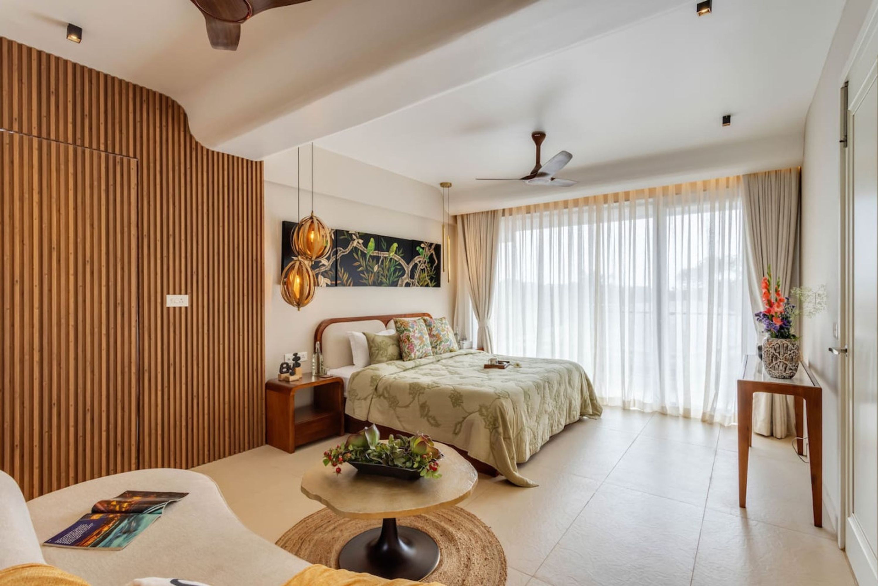 Une chambre à coucher moderne avec un lit, une table de chevet et une table basse ronde.