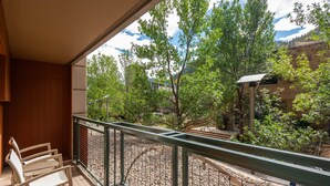 Uma varanda com vista para um jardim e um edifício ao fundo.