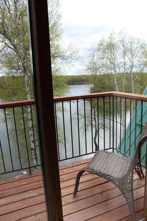 A wooden deck with a metal railing overlooking a body of water surrounded by trees. - Private lakefront cabin with WiFi in charming Talkeetna, Alaska (Talkeetna)