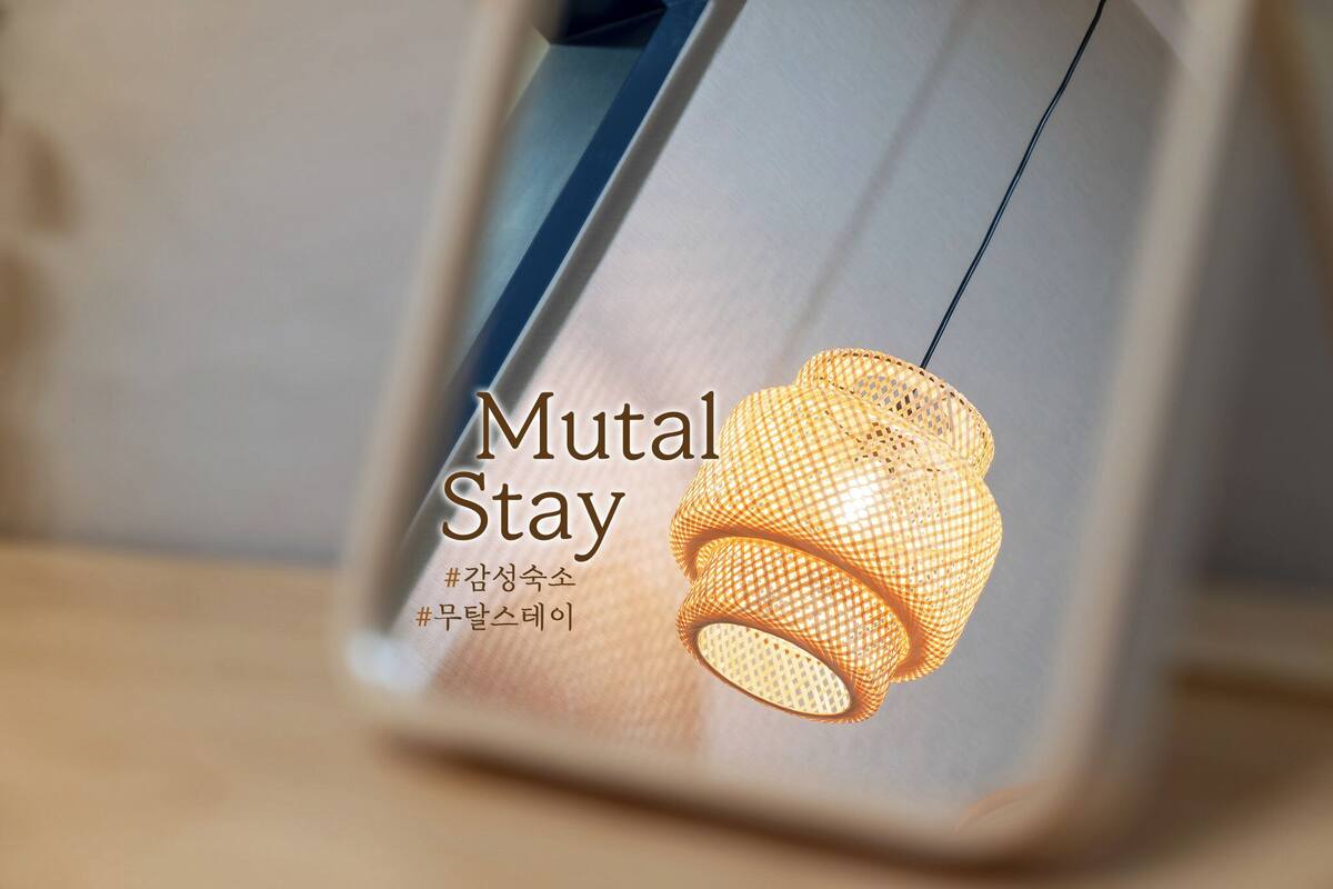 A framed picture of a woven lamp with the text "Mutal Stay" and Korean text below it.