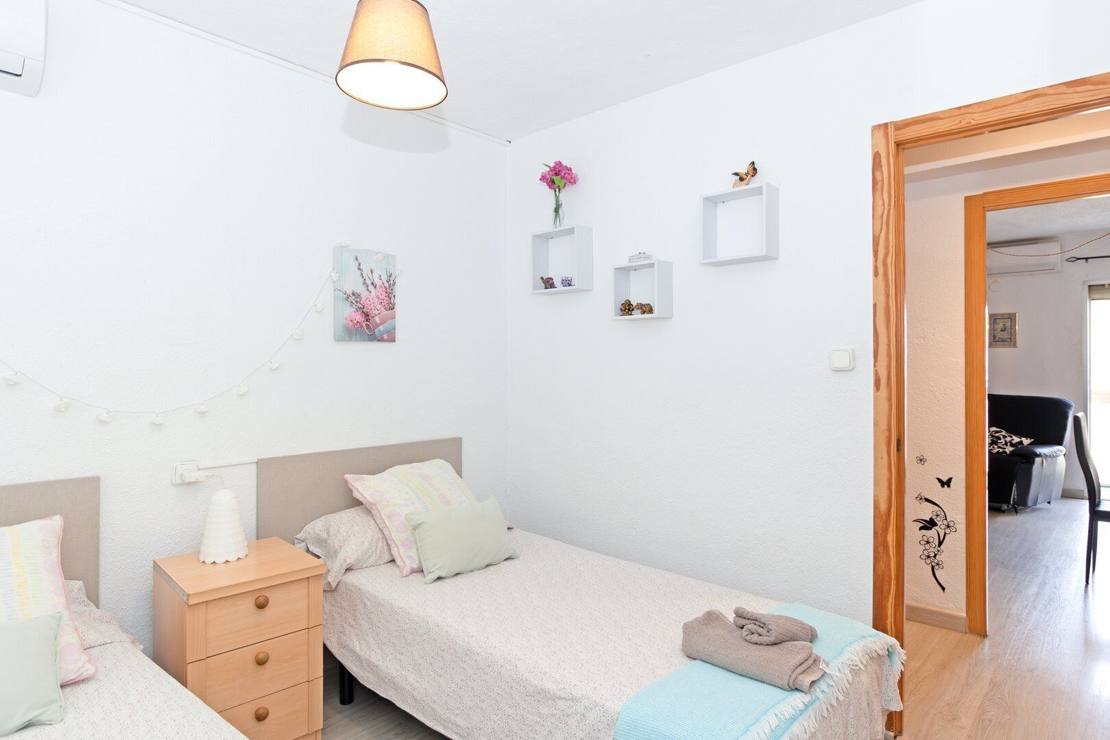 A bedroom with a bed, bedside tables, a lamp, and wall decorations.