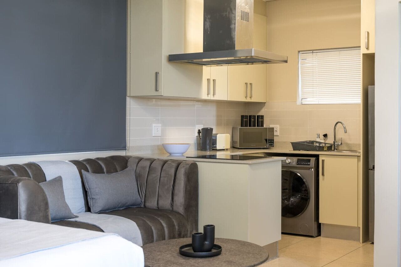 A compact kitchen with a built-in oven, microwave, and washing machine.