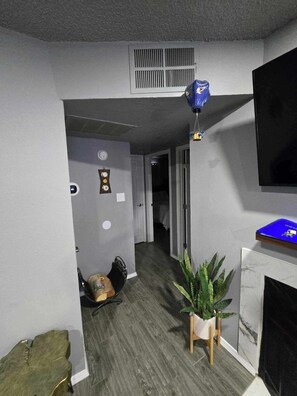 Cozy retreat with a grey wall, decorative clock, and potted plant.