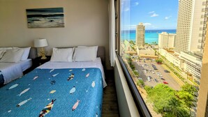 A hotel room with two beds, a view of the city and ocean, and a painting on the wall. - Part Ocean View, Beach Theme 23rd Fl, Free Parking with WiFi, AC  (Honolulu)