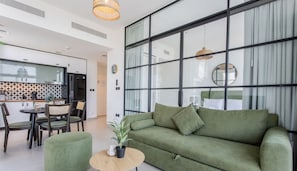 Relax in this spacious living area with a large sofa, dining table, and kitchenette.