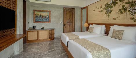 Habitación de hotel con una cama grande, cabecera de madera, un cuadro, un televisor y un escritorio con lámpara.