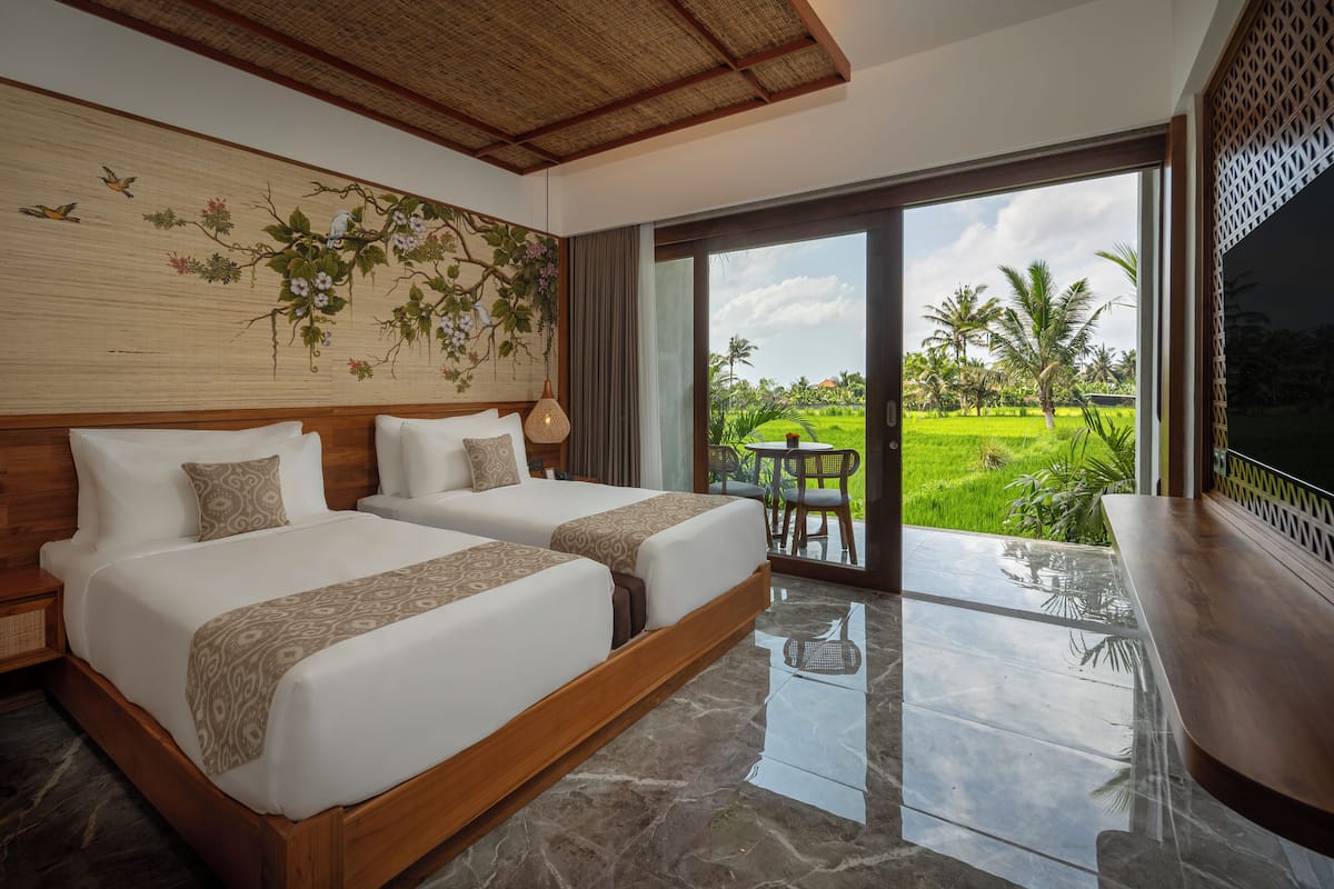 A hotel room with two beds, a large window, a view of a green landscape, and a wooden ceiling.