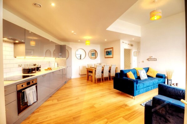 A modern kitchen with a dining area and a living room.