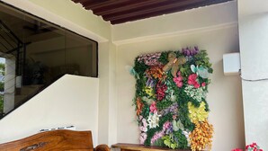 Un banc en bois et une composition florale fixée au mur.