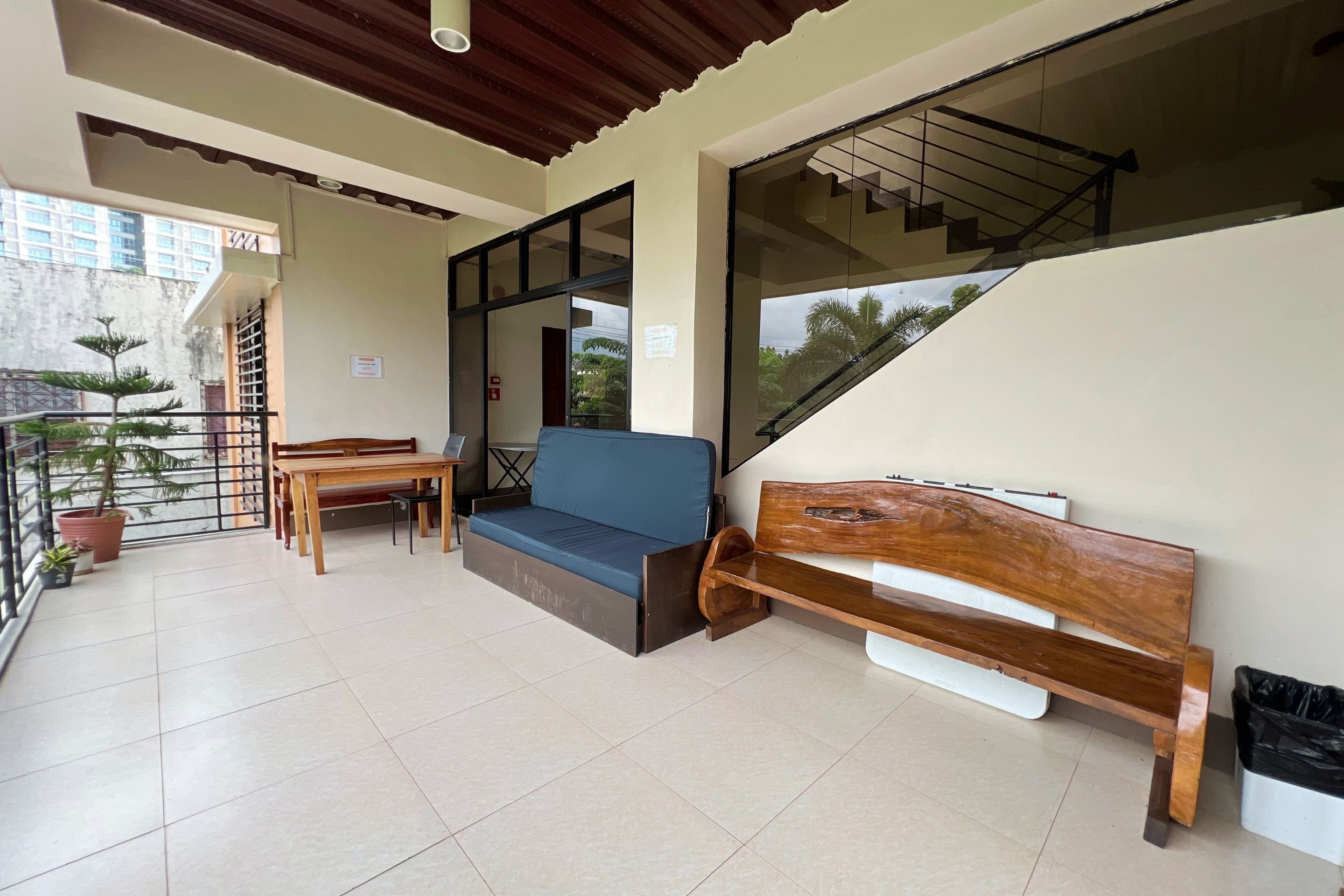 A modern interior with a wooden bench, a blue sofa, and a dining table.