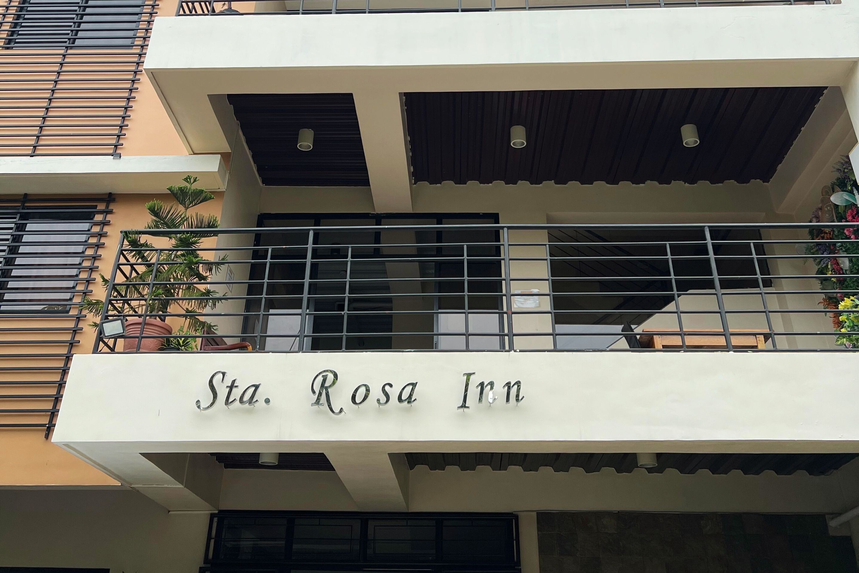 Un bâtiment avec une enseigne indiquant « Sta. Rosa Inn » sur le balcon.
