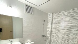 A modern bathroom with a white sink, toilet, and shower. - Maganda Hotel-San Fernando (Bacolor)