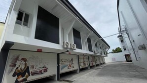 A building with large windows and air conditioning units. There are posters on the walls and a sign that says "No Smoking". - Maganda Hotel-San Fernando (Bacolor)