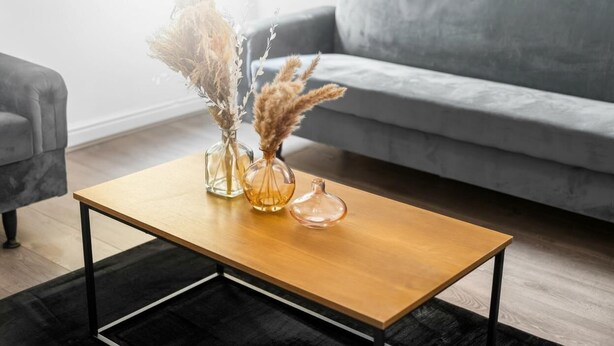 A modern living room with a wooden coffee table, two vases with dried plants, and a grey sofa. - Apartment 1 Bedroom,Sleeps6,Parking (Birmingham)