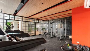 A modern gym with a treadmill, weight bench, and various exercise equipment. - Inviting To Your Home Near The City Life (Cebu)