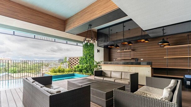 A rooftop terrace with a pool, outdoor seating, and a bar area. - Inviting To Your Home Near The City Life (Cebu)