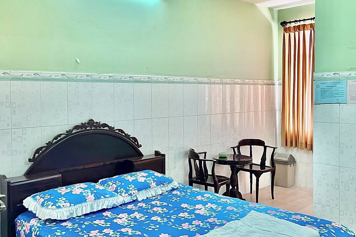 A bedroom with a bed, a desk, and a chair.