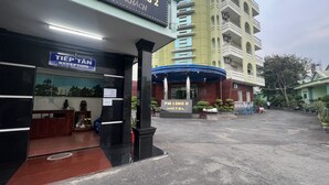 A hotel entrance with a reception desk, a sign for 'San PhI Long 2', and a sign for 'Phi Long II Hotel'. - Phi Long 2 Hotel Thu Dau Mot (Ho Chi Minh City)