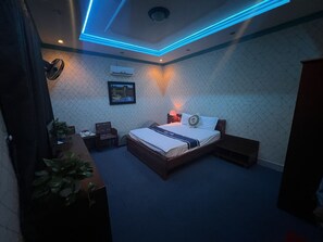 Un dormitorio moderno con cama, mesitas de noche, un escritorio y una silla.