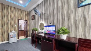 A modern room with a wooden desk, a computer, and two potted plants. - Phi Long 2 Hotel Thu Dau Mot (Ho Chi Minh City)