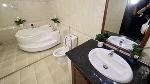 A modern bathroom with a bathtub, toilet, sink, and a large mirror. - Phi Long 2 Hotel Thu Dau Mot (Ho Chi Minh City)