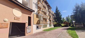Un edificio con un cartel que indica 'MEIJE 7-9' y una estructura de madera con un letrero para 'SPORT 2000' y 'RESTAURANT'.