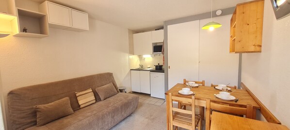 A compact living space with a sofa, dining table, and kitchen area. - 4-person studio near the slopes (Les Deux Alpes)