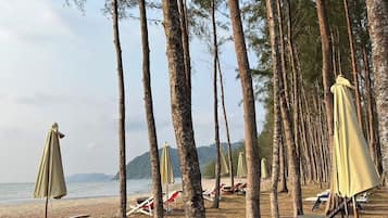 Na praia, espreguiçadeiras, toalhas de praia