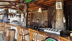 A rustic bar area with a Heineken sign, wooden furniture, and a vintage jukebox. - 7 Heaven camping Lanta (Ko Lanta)
