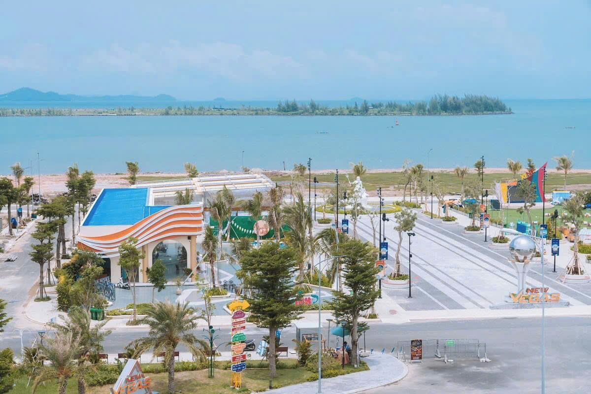 Un hotel con techo azul, palmeras y vista al mar.