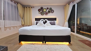 Une chambre d’hôtel moderne avec un grand lit, un élément décoratif mural et une vue sur l’extérieur.