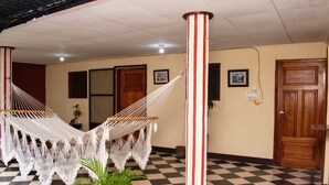 A checkered floor, a hammock, a wooden door, and a column.