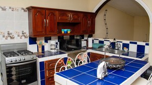 A kitchen with a stove, oven, microwave, and coffee maker.
