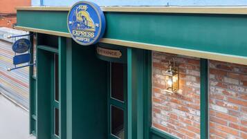 A building entrance with a sign reading "EXPRESS PASSPORT" and a "ENTRANCE" sign.