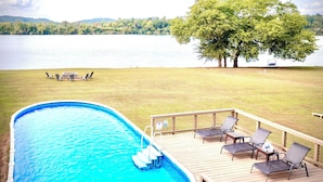 A swimming pool with a deck, lounge chairs, and a table. - Lakefront Oasis:Big Back Porch, Private Pool & Hot Tub! All on Lake Chickamauga  (Decatur)