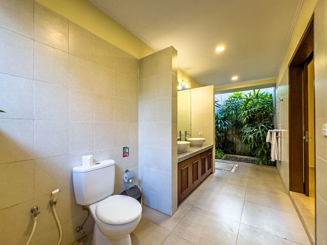 A modern bathroom with a toilet, sink, and mirror.
