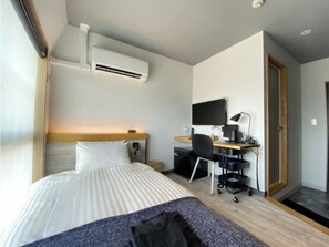 Comfortable retreat with a neatly made bed, flat-screen TV, and desk area.