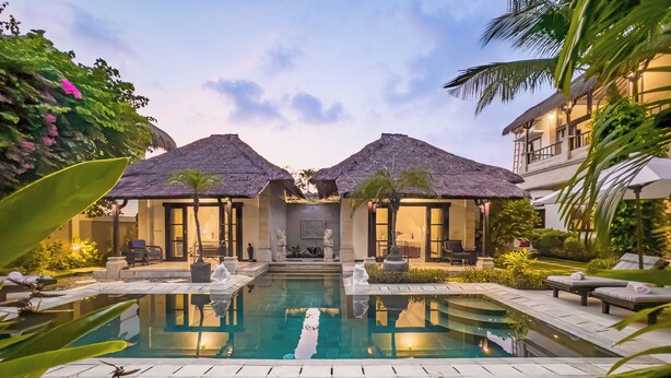A resort with a central pool, two thatched-roof structures, and outdoor seating. - Villa Bugis Kayu Aya Seminyak (Seminyak)