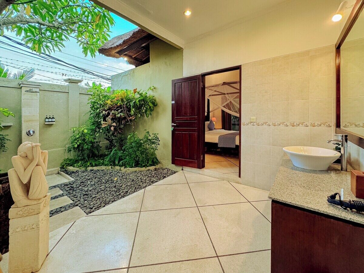 A bathroom with a large sink, a mirror, and a shower area.