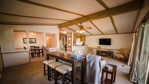 A spacious living area with a dining table, chairs, a sofa, and a television. - Serene 3-Bedroom Getaway with Stunning Lake Views (Aberdeen)