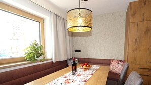 Ein Essbereich mit Holztisch, einer Tischdecke mit Blumenmuster und einer Obstschale.