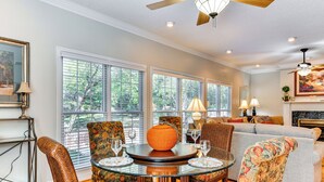 A spacious living room with a round glass table, floral upholstered chairs, and a grey sofa. - 1 Mi to Dtwn: Home w/ Fire Pit & Deck in Hudson! (Hudson)
