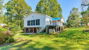 A white two-story house with a covered deck and a brick foundation. - 1 Mi to Dtwn: Home w/ Fire Pit & Deck in Hudson! (Hudson)