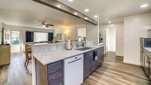A modern kitchen with a large island, dark wood cabinets, and a dishwasher. - < 1 Mi to Dwtn: Valparaiso Family Home (Valparaiso)