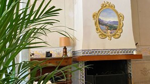 Una habitación con chimenea, un espejo decorativo y una planta.