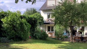 A house with a garden, a balcony, and a dining area with outdoor furniture. - Stylish apartment in the middle of the Ruhr area (Bochum)