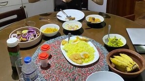 A dining table with various dishes, a water bottle, and a notebook. - Sanora Hostel (Sigiriya)