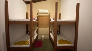 A narrow room with bunk beds arranged in two rows. - Sanora Hostel (Sigiriya)